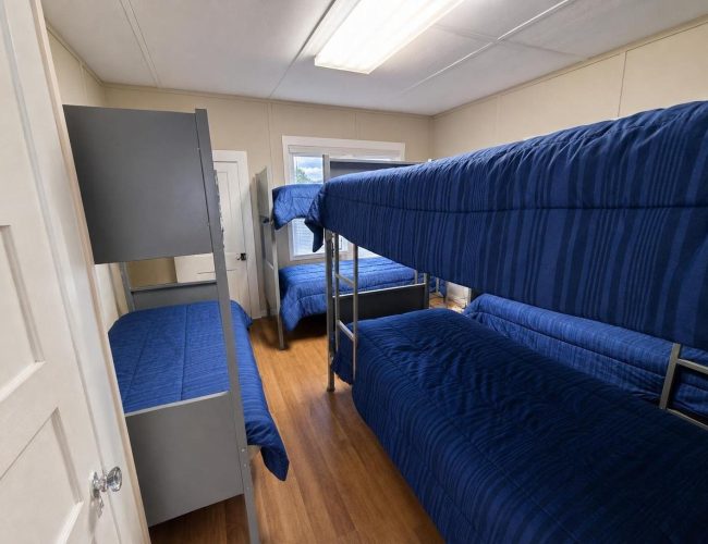 3E Ranch bunk room with blue-covered metal bunk beds