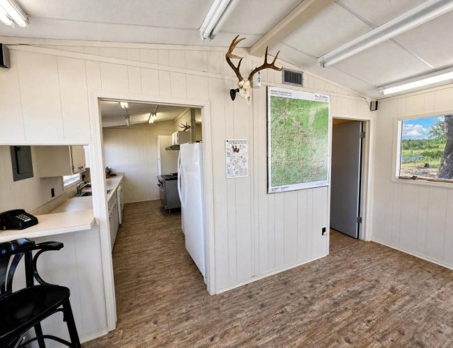 3E Ranch mess hall interior with wall map and kitchen doorway