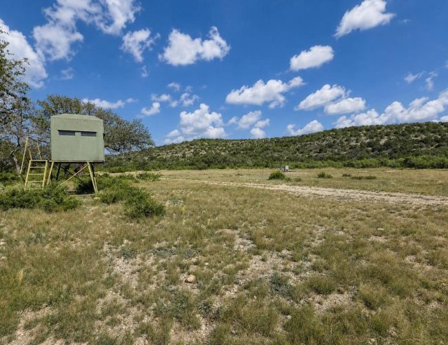 3E Ranch elevated hunting blind overlooking open grassy field and dirt road