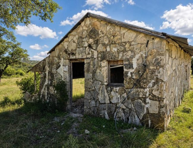 3E Ranch old stone building with metal roof and open doorway